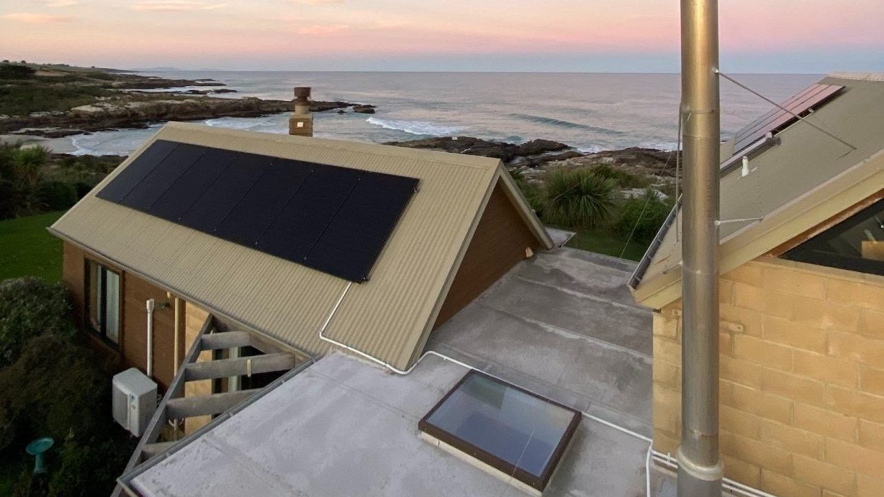 All-black solar array on a coastal home at dusk