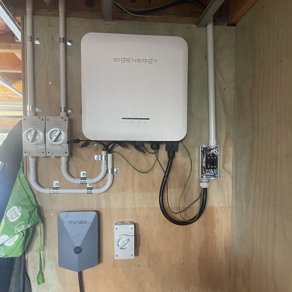 Wall-mounted Sigenergy inverter with isolator switches and conduit