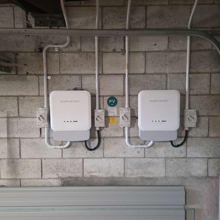 Isolator switches, protection and conduit on a wall-mounted solar install